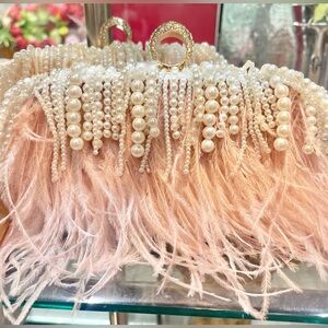 Ostrich feather light pink with diamond ring clutch comes with strap.